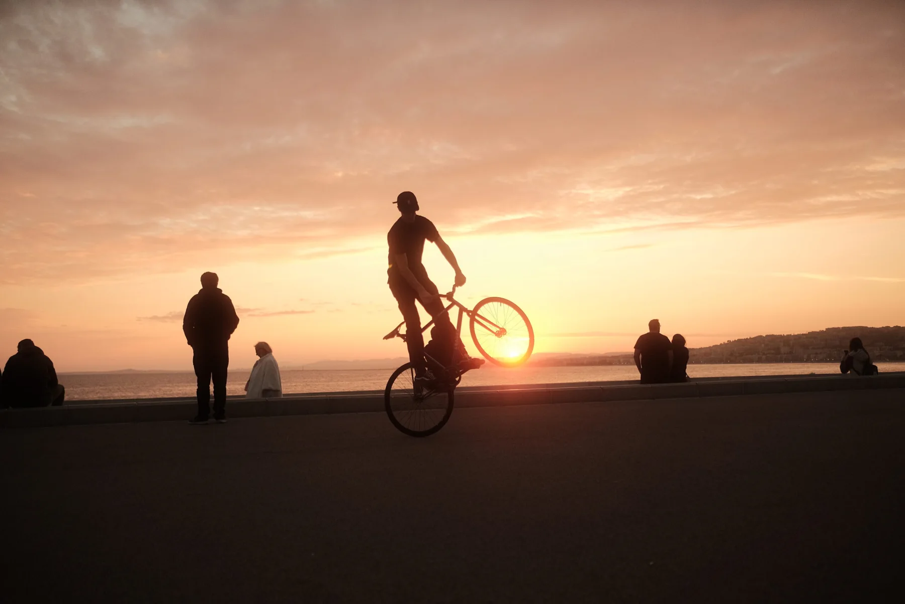 El Fakijoe holding a wheelie against the sunset