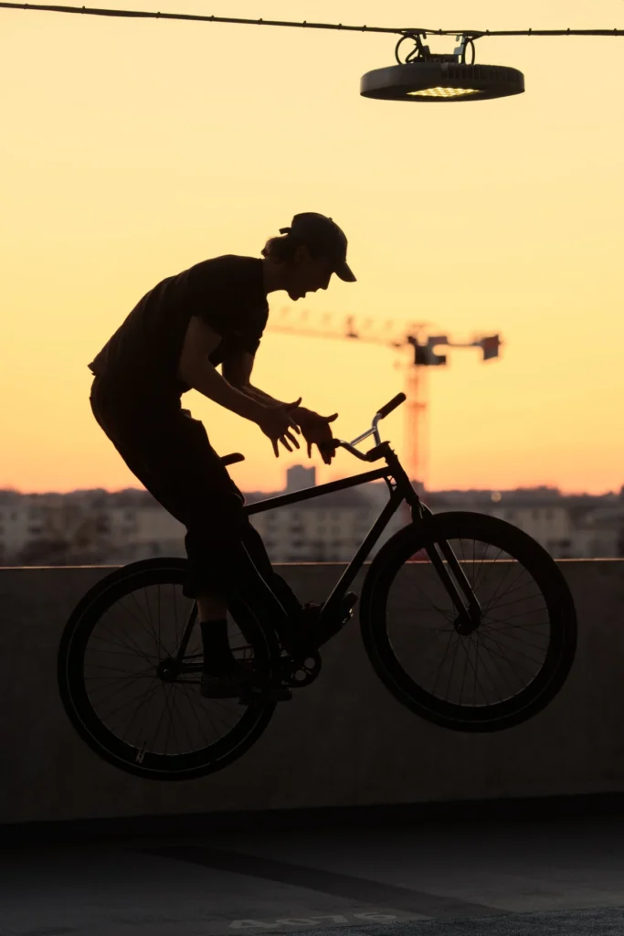 A fixed gear rider balancing against warm evening light
