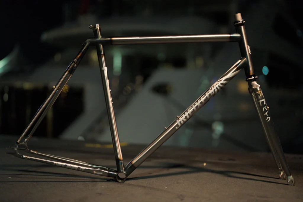 The complete raw steel JRI Grit frame in profile against a softly lit wall