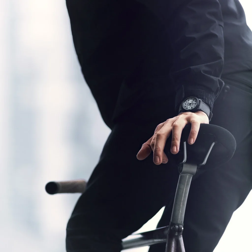 Charlie Paris GRX watch worn by El Fakijoe with his hands resting on the bicycle handlebar